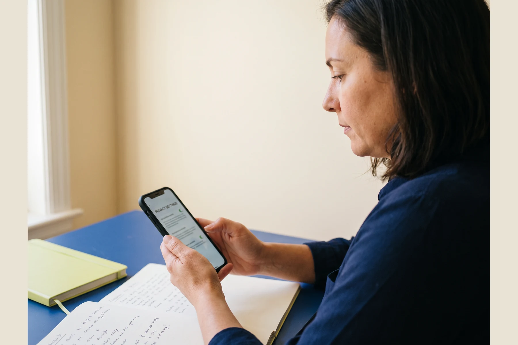 Person considering a phone in a bright room